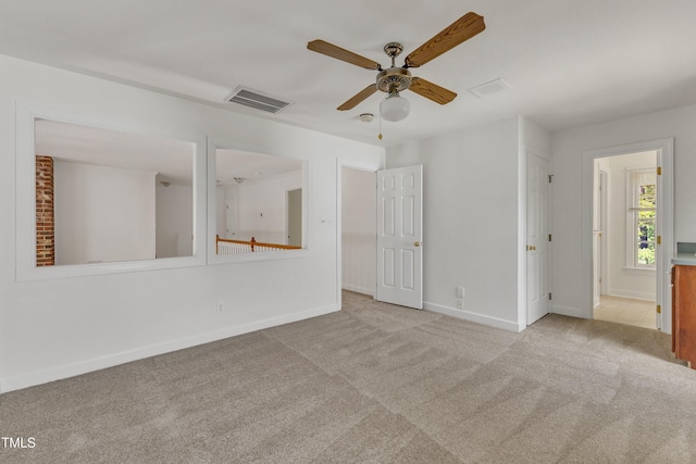 carpeted empty room featuring ceiling fan, baseboards, and visible vents