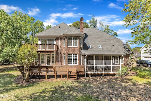back of property featuring a lawn, a sunroom, a chimney, and brick siding