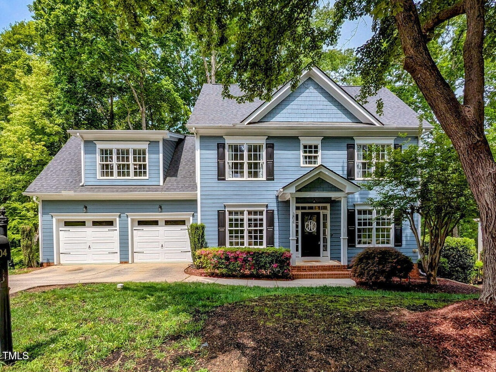 204 Flint Point Ln, Holly Springs, NC 27540 - colonial inspired home featuring a garage, a shingled roof, a front lawn, and concrete driveway