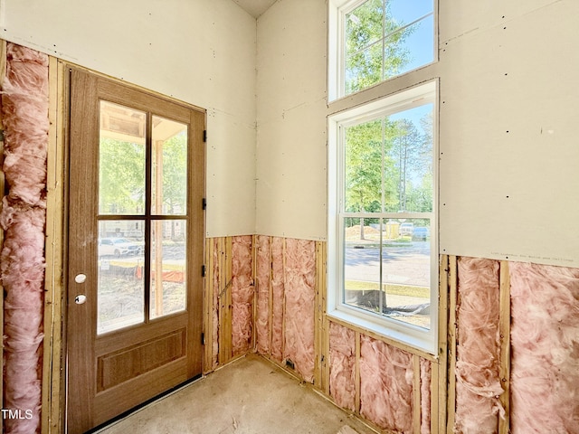 doorway with a wainscoted wall and a high ceiling