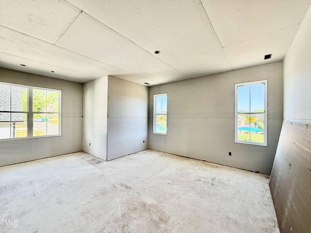 unfurnished room with unfinished concrete floors