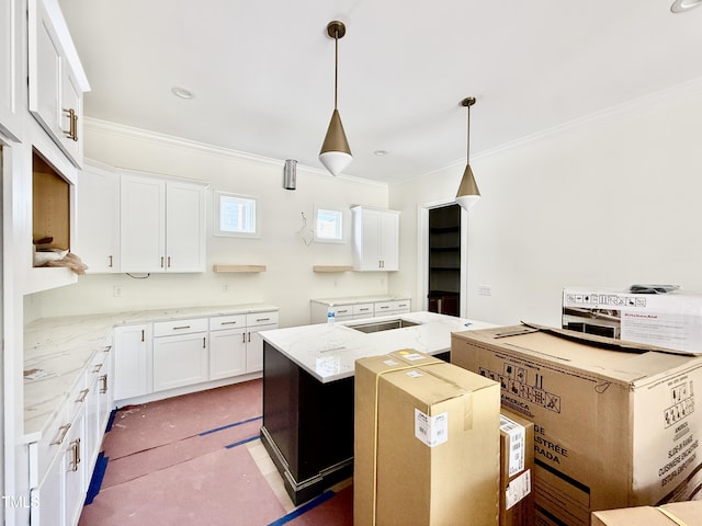 3817 Coach Lantern Ave, Wake Forest, NC 27587 - kitchen with a kitchen island with sink, crown molding, white cabinetry, decorative light fixtures, and light stone counters