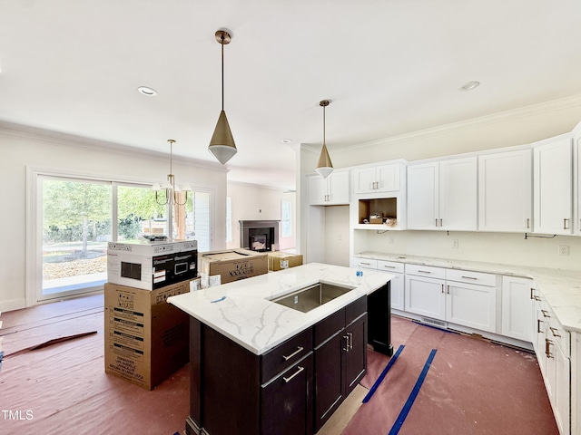 3817 Coach Lantern Ave, Wake Forest, NC 27587 - kitchen featuring a kitchen island, crown molding, white cabinetry, black electric cooktop, and light stone countertops