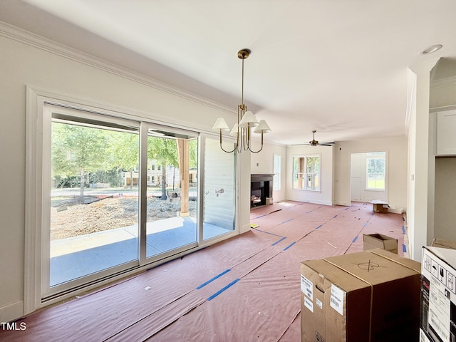 3817 Coach Lantern Ave, Wake Forest, NC 27587 - unfurnished dining area with ornamental molding, a chandelier, a fireplace with raised hearth, and ceiling fan