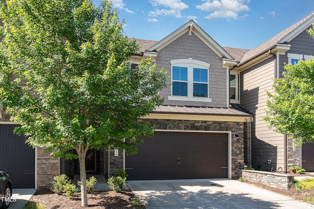 view of front of property with a garage, stone siding, metal roof, a standing seam roof, and concrete driveway