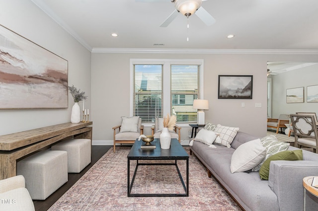 living room featuring a ceiling fan, ornamental molding, and wood finished floors
