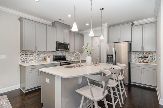 kitchen featuring gray cabinets, backsplash, a sink, ornamental molding, and stainless steel appliances