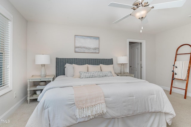 bedroom featuring baseboards, multiple windows, a ceiling fan, and light colored carpet