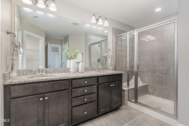 bathroom featuring visible vents, a sink, tile patterned flooring, and a stall shower