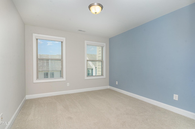 carpeted spare room featuring baseboards