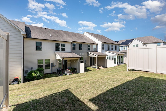 rear view of house with a residential view, a yard, and roof with shingles