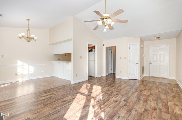 unfurnished living room with wood finished floors, ceiling fan with notable chandelier, baseboards, visible vents, and lofted ceiling