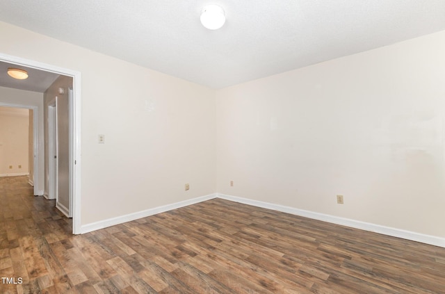 spare room featuring wood finished floors and baseboards