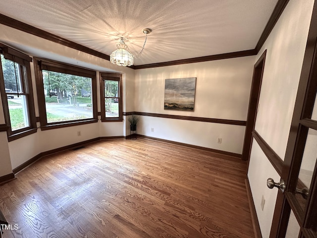 2708 Halfhitch Trl, Raleigh, NC 27615 - unfurnished room with a chandelier, ornamental molding, wood finished floors, and baseboards