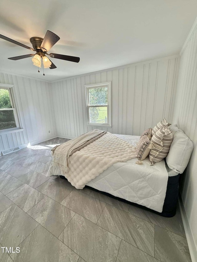 bedroom featuring ceiling fan and a decorative wall