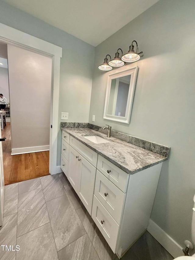 bathroom featuring marble finish floor, baseboards, and vanity
