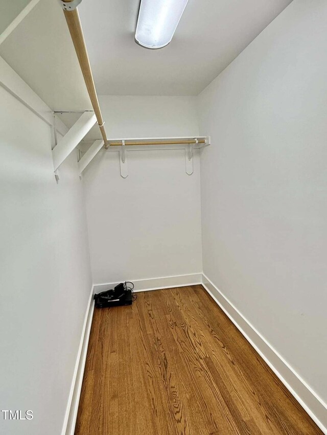 walk in closet with wood finished floors