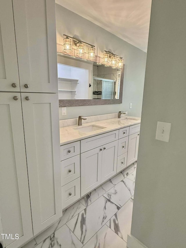 bathroom featuring double vanity, marble finish floor, a stall shower, and a sink