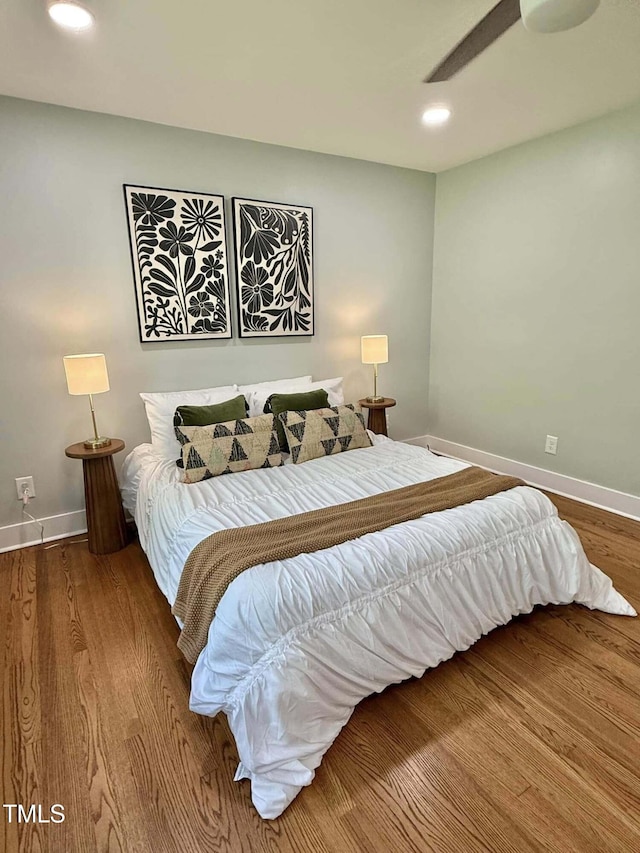 bedroom with baseboards, wood finished floors, and recessed lighting