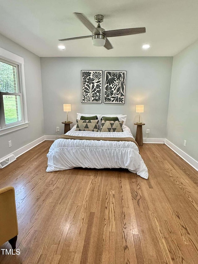 bedroom with a ceiling fan, wood finished floors, baseboards, visible vents, and recessed lighting