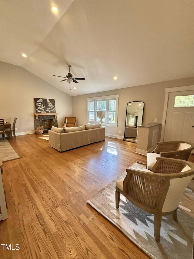 living room with ceiling fan, lofted ceiling, light wood finished floors, and plenty of natural light
