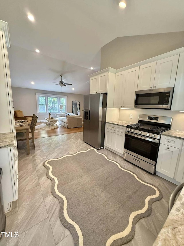 kitchen featuring ceiling fan, white cabinetry, lofted ceiling, appliances with stainless steel finishes, and recessed lighting