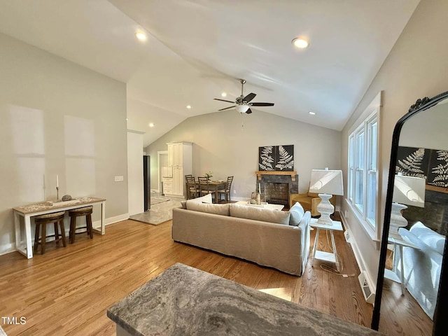 living area with recessed lighting, lofted ceiling, a ceiling fan, and wood finished floors