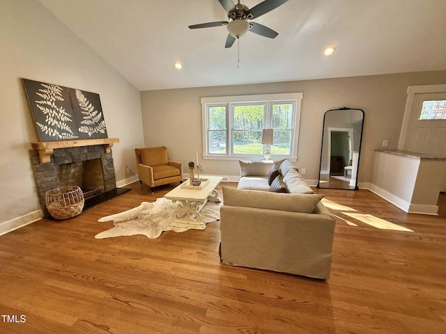 living room with baseboards, recessed lighting, lofted ceiling, a ceiling fan, and a fireplace