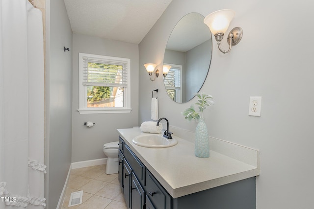 bathroom featuring vanity, visible vents, toilet, tile patterned floors, and baseboards