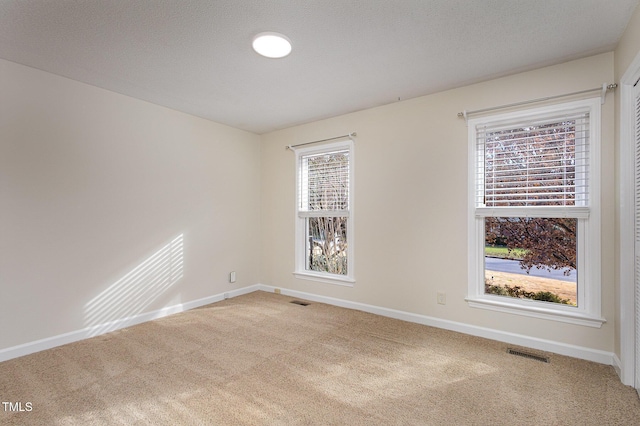 unfurnished room with baseboards, visible vents, and carpet floors