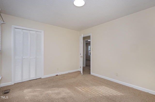unfurnished bedroom featuring a closet, carpet flooring, visible vents, and baseboards