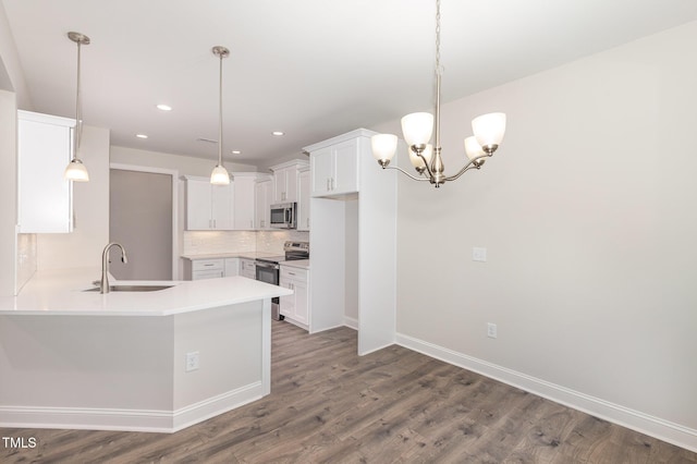 1000 Peedin Rd, Selma, NC 27576 - kitchen with stainless steel appliances, a peninsula, wood finished floors, a chandelier, and backsplash