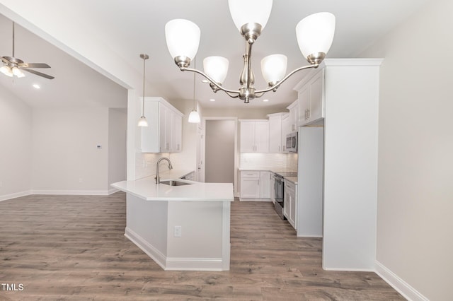 1000 Peedin Rd, Selma, NC 27576 - kitchen with appliances with stainless steel finishes, a peninsula, backsplash, wood finished floors, and a chandelier