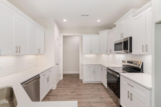 1000 Peedin Rd, Selma, NC 27576 - kitchen with stainless steel appliances, recessed lighting, light countertops, white cabinetry, and light wood finished floors