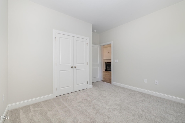 1000 Peedin Rd, Selma, NC 27576 - unfurnished bedroom featuring carpet flooring, a closet, and a glass covered fireplace