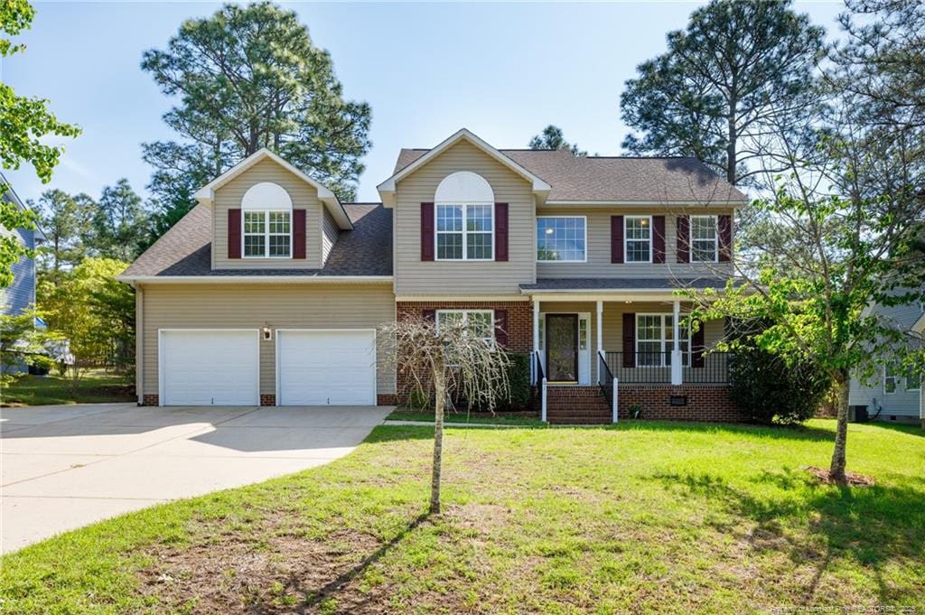 61 Lakewind Ct, Sanford, NC 27332 - view of front facade featuring covered porch, a shingled roof, a front yard, and concrete driveway