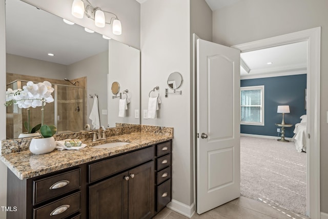 bathroom featuring crown molding, vanity, baseboards, tile patterned floors, and a stall shower
