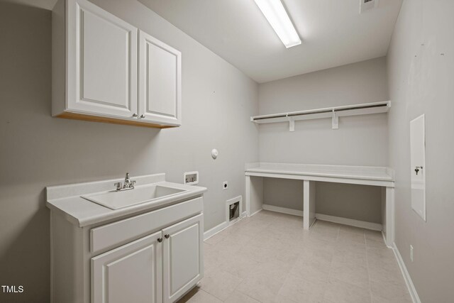 washroom featuring cabinet space, washer hookup, a sink, baseboards, and electric dryer hookup