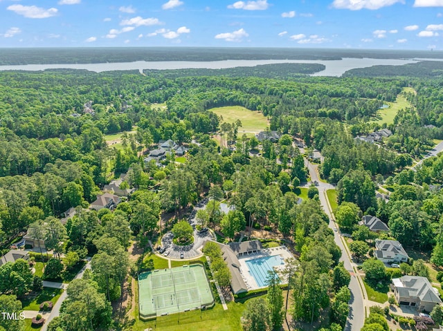 birds eye view of property featuring a water view and a view of trees