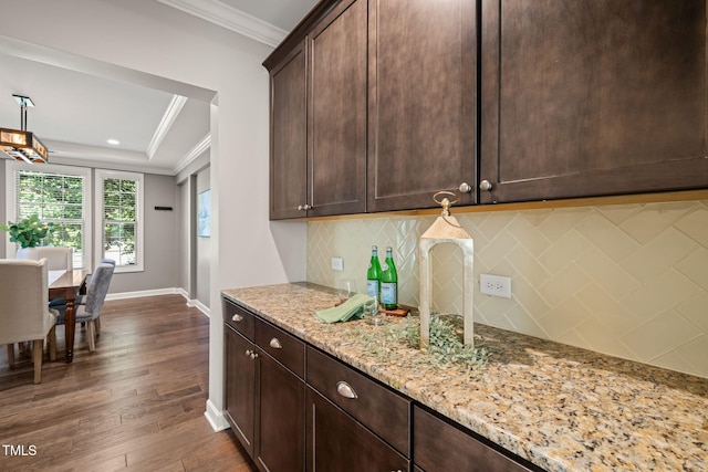 kitchen featuring crown molding, baseboards, dark wood-style flooring, and tasteful backsplash