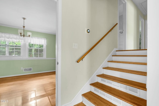 905 Cindy St, Cary, NC 27511 - stairs featuring attic access, visible vents, wood finished floors, baseboards, and an inviting chandelier