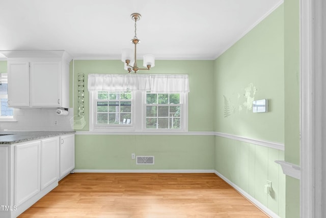 905 Cindy St, Cary, NC 27511 - unfurnished dining area featuring visible vents, ornamental molding, light wood-style floors, baseboards, and a chandelier