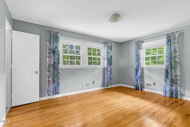905 Cindy St, Cary, NC 27511 - spare room featuring visible vents, wood finished floors, and a healthy amount of sunlight