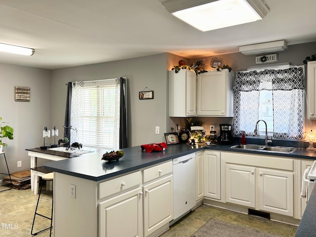 107 N Pearl St, Princeton, NC 27569 - kitchen with a sink, white dishwasher, a peninsula, dark countertops, and light stone finish flooring
