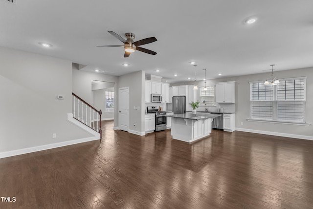 kitchen with ceiling fan with notable chandelier, plenty of natural light, baseboards, and appliances with stainless steel finishes
