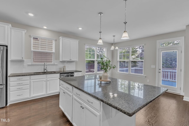 kitchen with a sink, white cabinetry, appliances with stainless steel finishes, and dark wood-style flooring