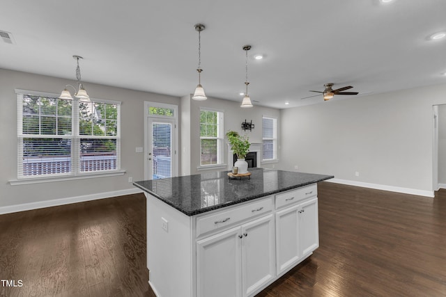 kitchen featuring visible vents, dark wood-type flooring, ceiling fan, and hanging light fixtures
