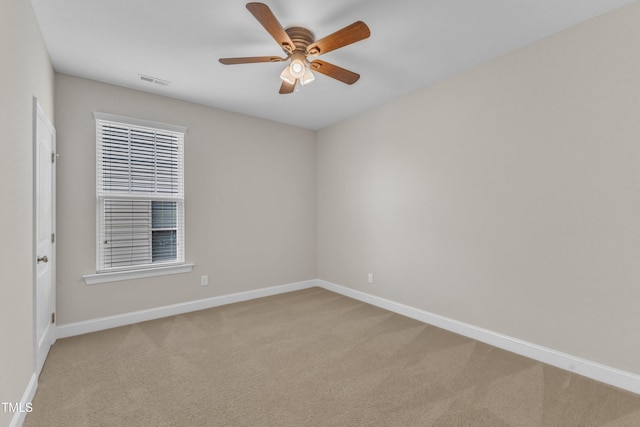 carpeted empty room featuring visible vents, a ceiling fan, and baseboards