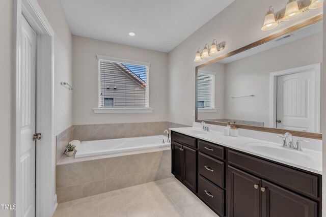 full bath with a garden tub, tile patterned flooring, a sink, and visible vents