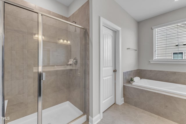 bathroom with a bath, baseboards, tile patterned flooring, and a stall shower